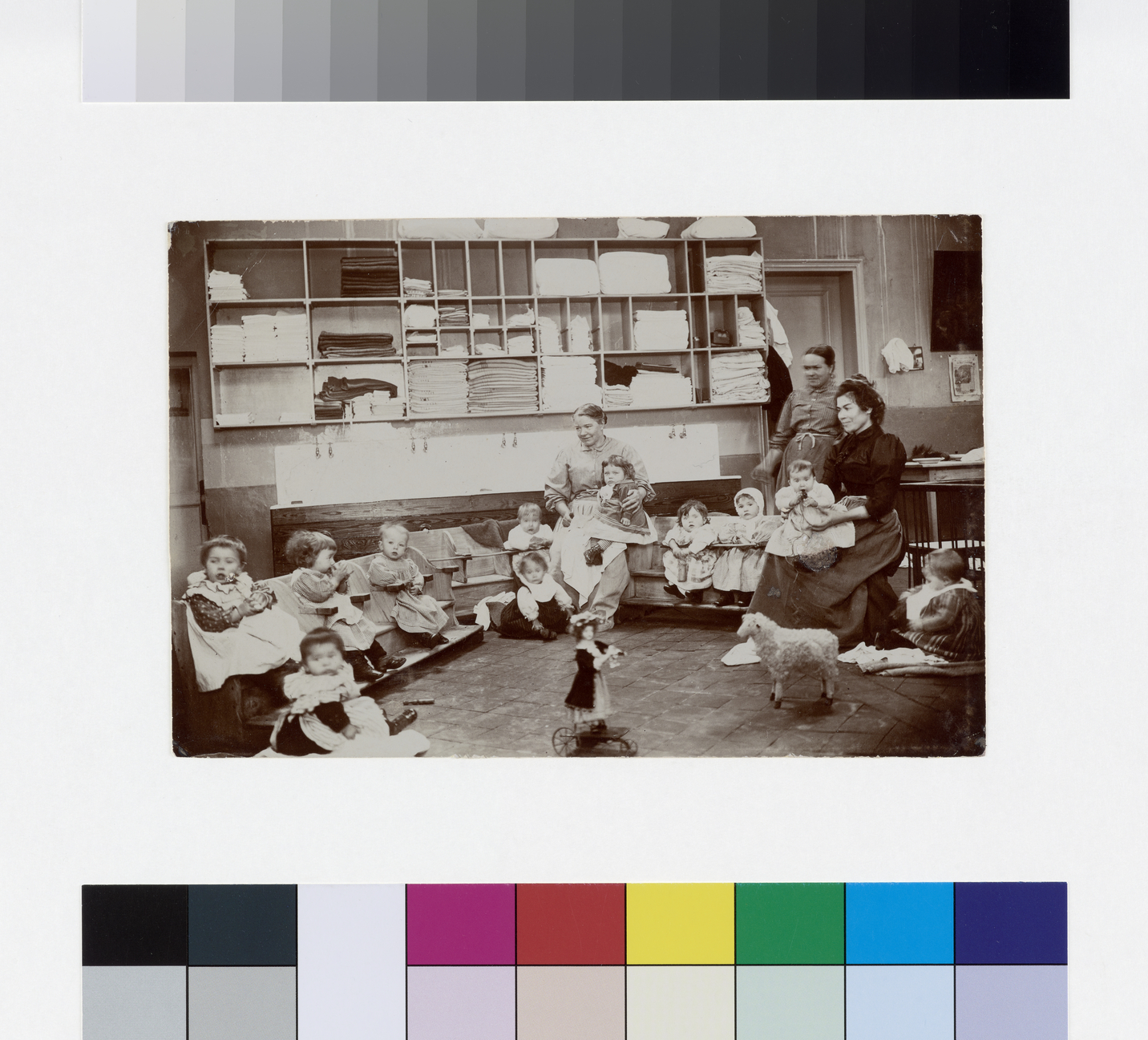 Groupe d'enfants et leurs nourrices dans une salle de la nourricerie du familistère de Guise_0