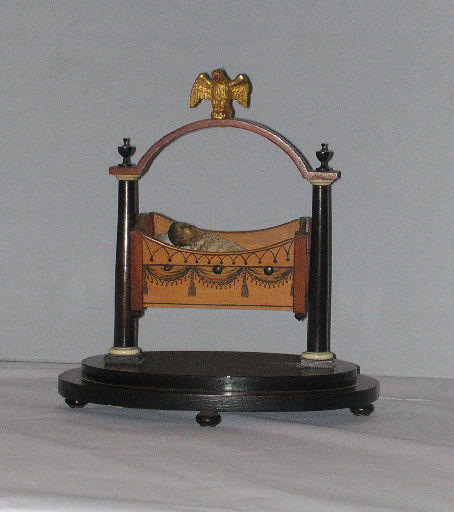 Berceau en bois avec bébé emmailloté_0