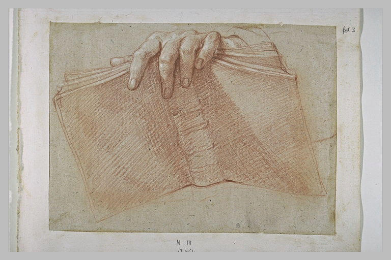 Main posée sur un livre ouvert_0