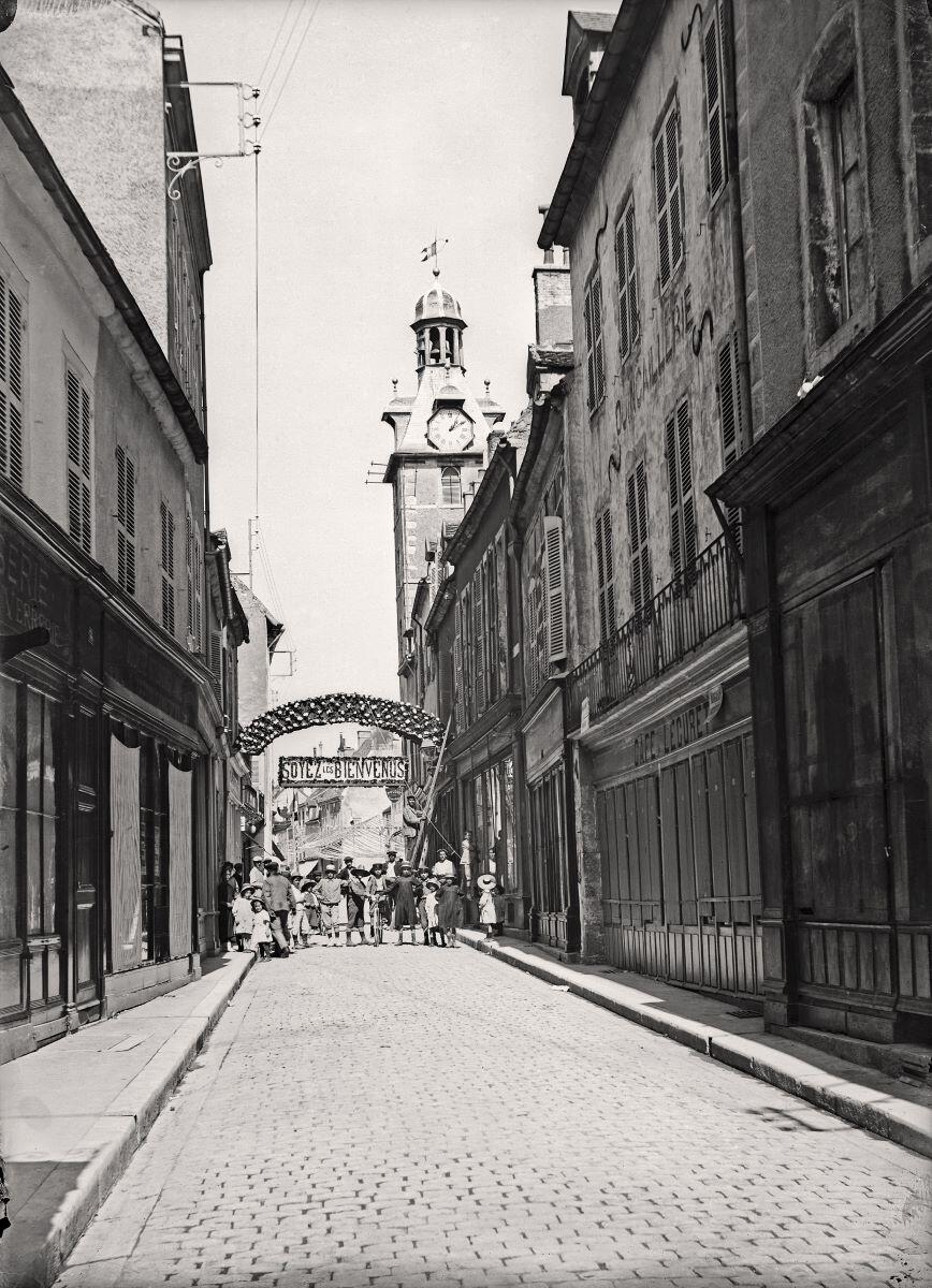 Nuits-Saint-Georges - “SOYEZ LES BIENVENUS”. Enfilade de la Grande rue avec le beffroi au fond à droite (titre usuel), Jules Misserey, 1ère moitié 20e siècle