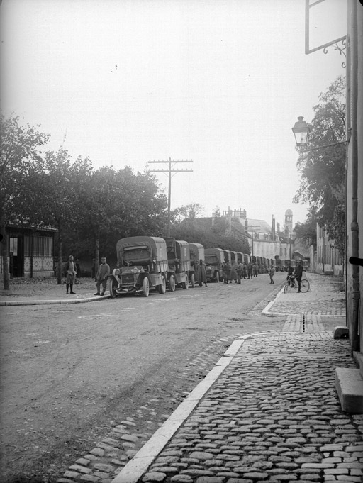 Convoi de camions militaires sur le rue Thurot, hôpital St Laurent au fond, halles à gauche (titre usuel), Jules Misserey, 1er quart 20e siècle