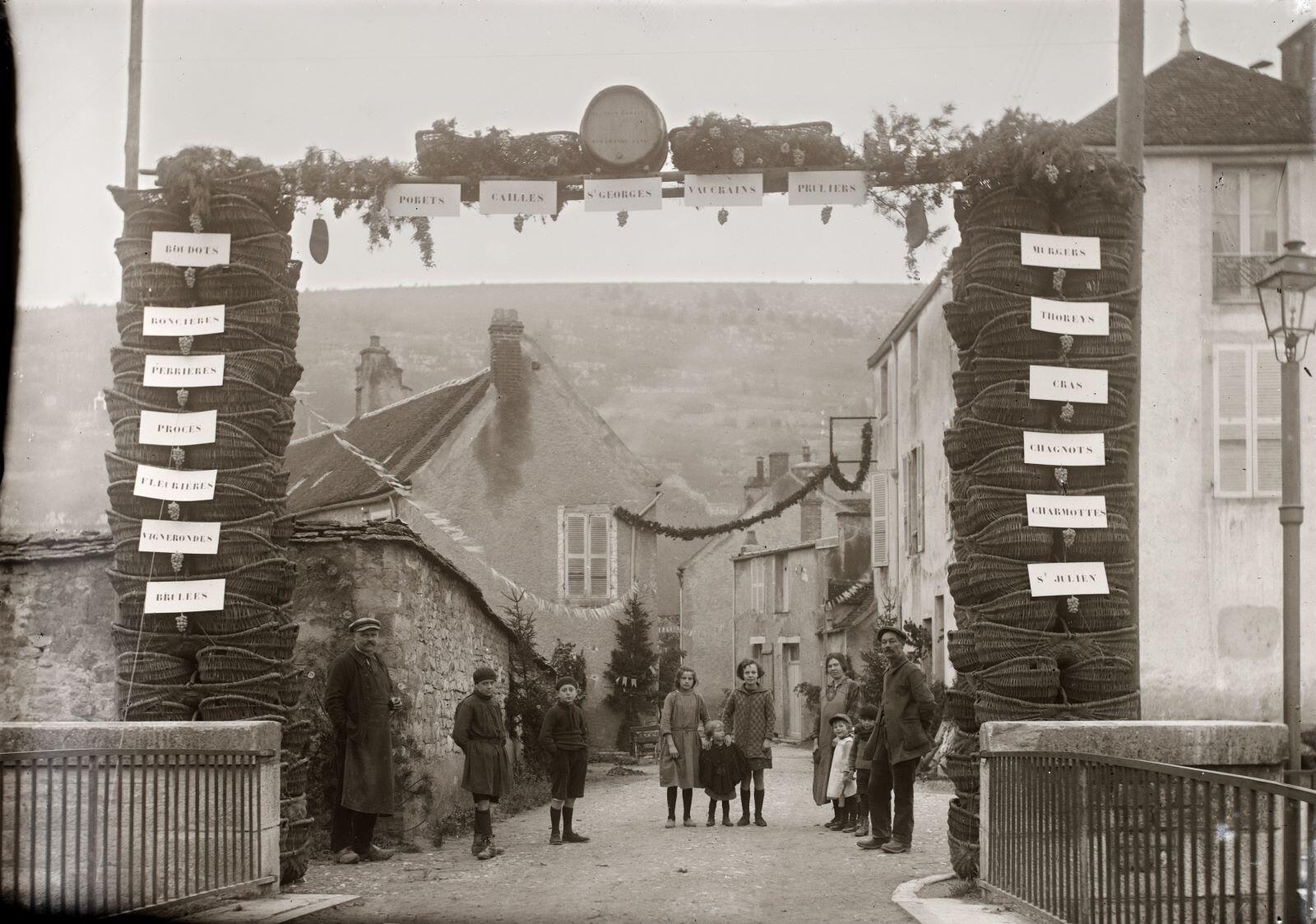Nuits-Saint-Georges - Vue sur rue avec personnages sous une arche portant les noms des climats du vignoble nuiton (titre usuel), Jules Misserey, 1900-1941