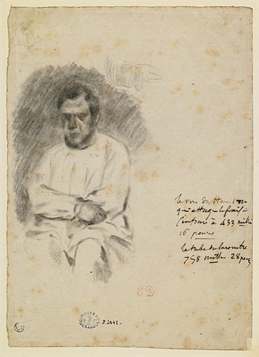 Un homme barbu assis, les bras croisés, portant une blouse_0