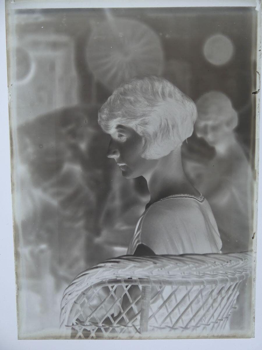 Jeune femme de profil (Andrée Cognard ?), assise dans un fauteuil en rotin, posant dans l'atelier de l'artiste_1