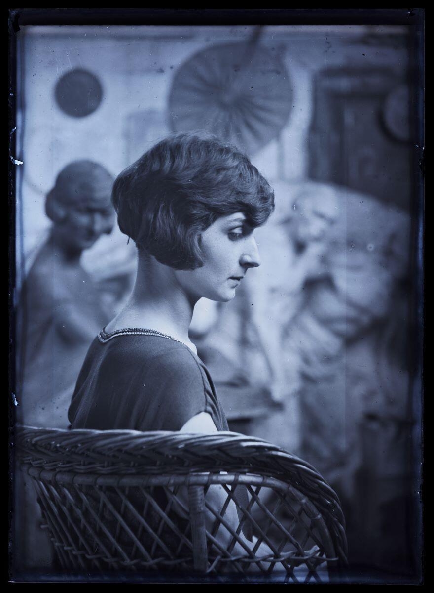 Jeune femme de profil (Andrée Cognard ?), assise dans un fauteuil en rotin, posant dans l'atelier de l'artiste_0