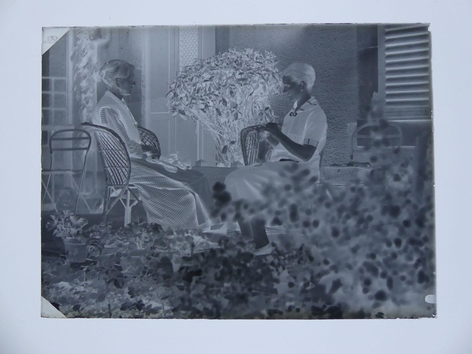 Louise Hertig cousant ou tricotant dans le jardin, accompagnée d'une femme plus âgée, Louis Hertig, 1ère moitié 20e siècle