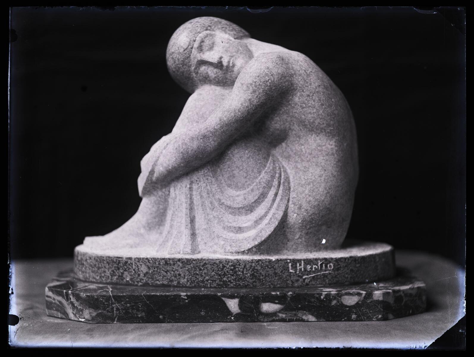 Groupe sculpté d'une femme assise, jambes repliées, la tête reposant sur ses genoux, photographiée dans l'atelier_0