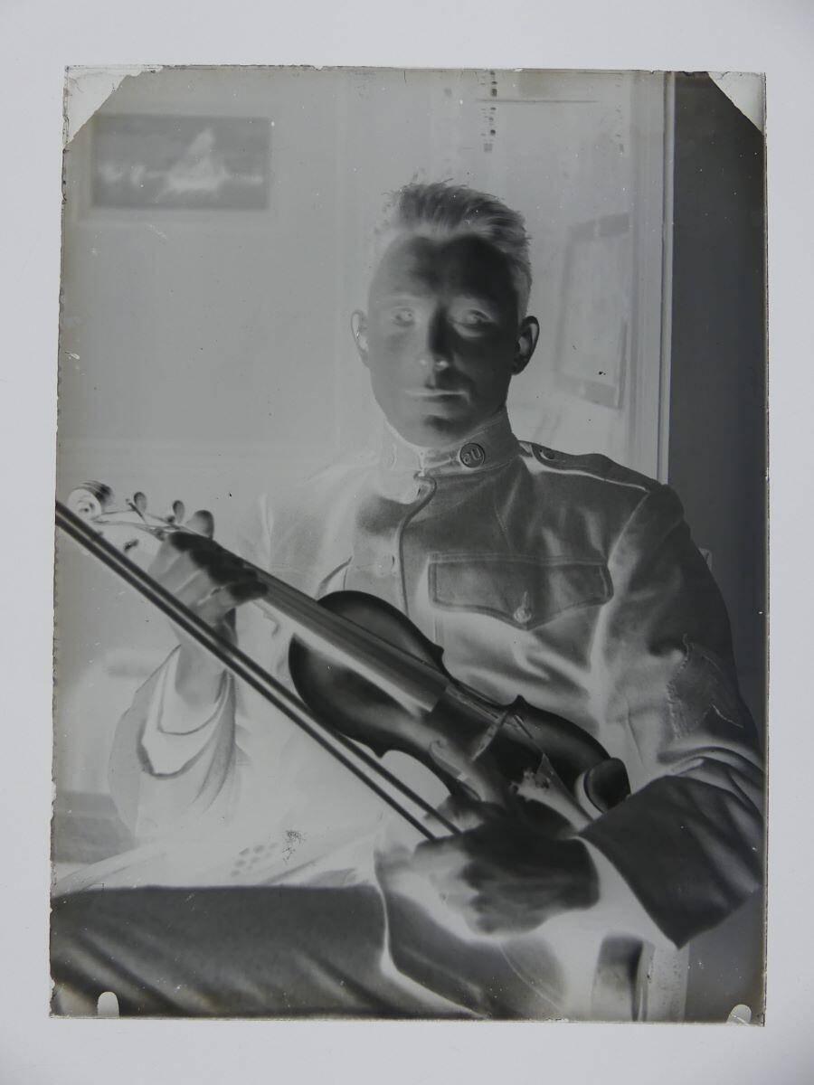 Soldat américain en uniforme posant assis, son violon entre les mains_1
