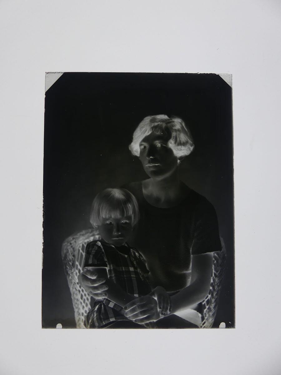 Portrait d'une jeune femme avec une petite fille sur les genoux, posant dans un fauteuil en osier_1