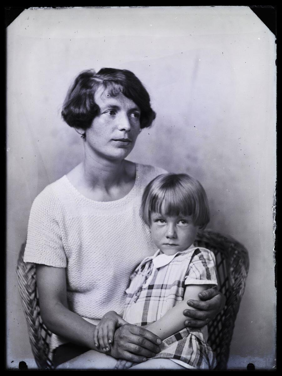 Portrait d'une jeune femme avec une petite fille sur les genoux, posant dans un fauteuil en osier_0