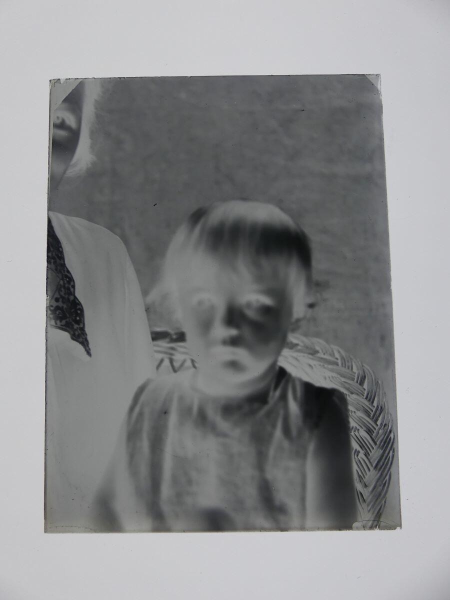 Portrait flou de James Hertig enfant posant sur les genoux d'une jeune femme, Louis Hertig, 1ère moitié 20e siècle
