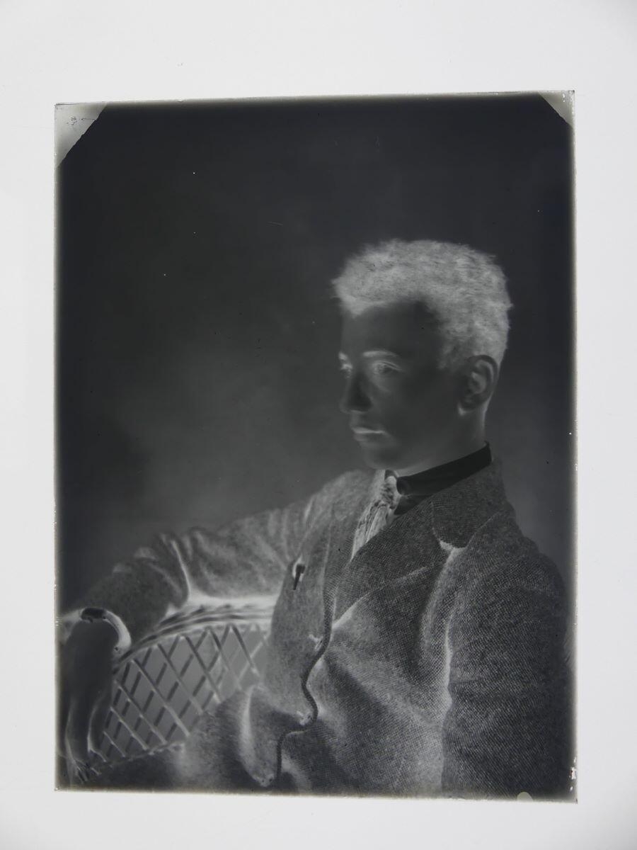 Portrait de jeune homme assis de 3/4 droit dans un fauteuil en rotin, Louis Hertig, 1ère moitié 20e siècle