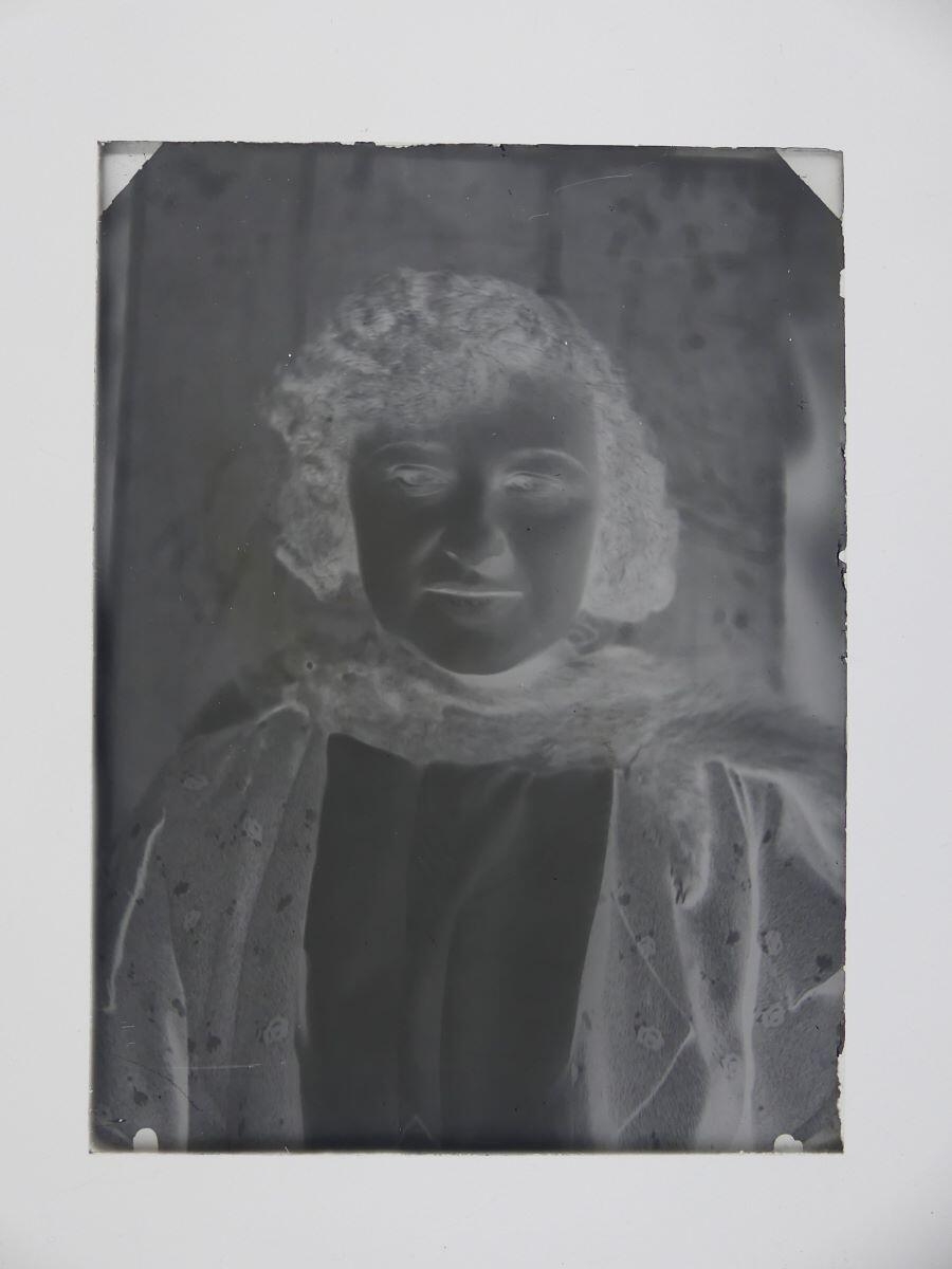 Jeune femme aux cheveux ondulés, un renard autour du cou, posant de face, en buste, dans l'atelier_1