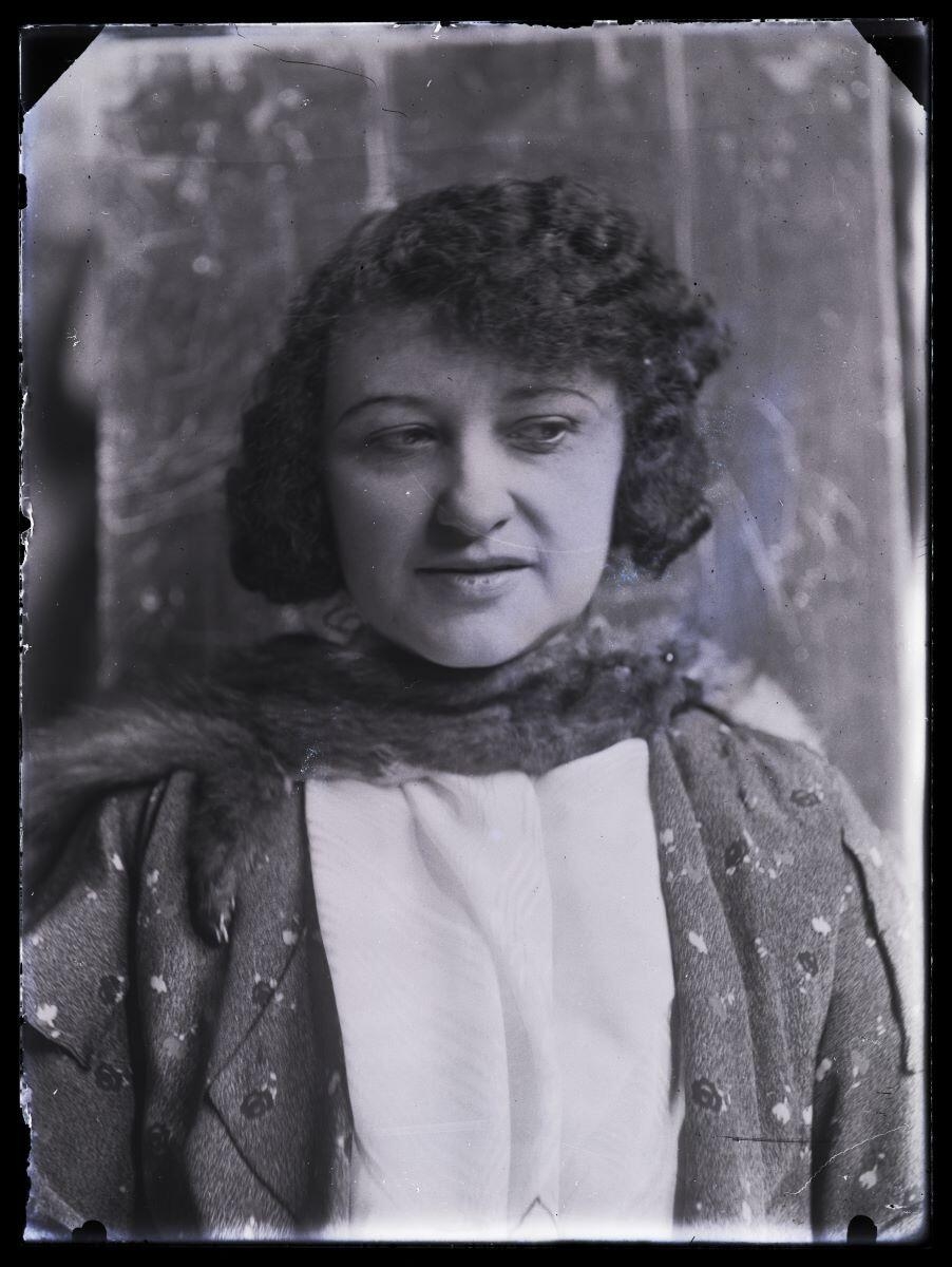 Jeune femme aux cheveux ondulés, un renard autour du cou, posant de face, en buste, dans l'atelier_0