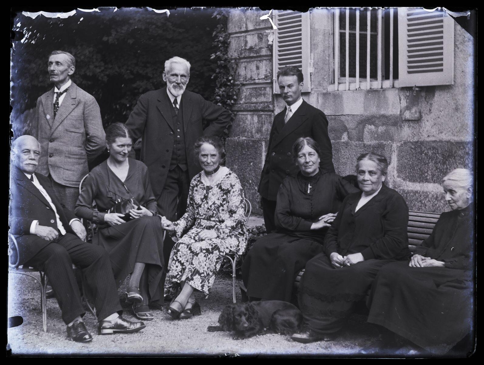 James Hertig adulte, sa mère, M. et Mme René Vallery-Radot et d'autres personnes posant dans un jardin, devant une maison, Louis Hertig, 1ère moitié 20e siècle