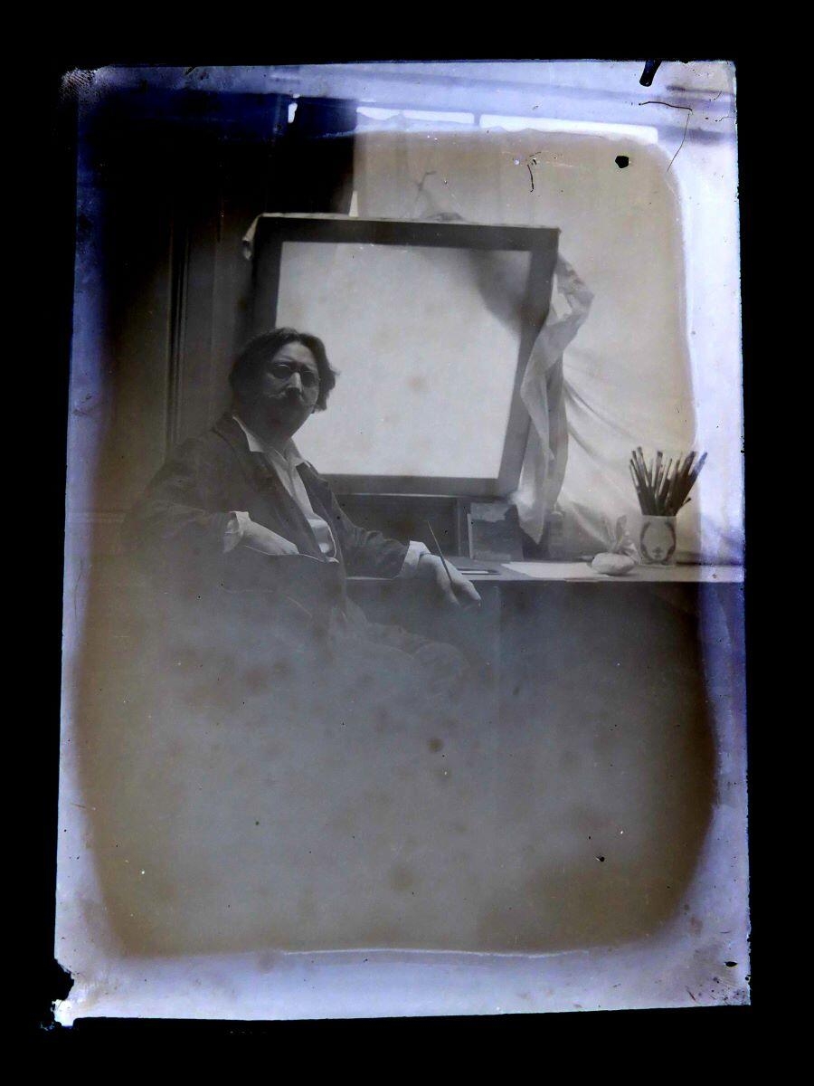 Portrait du peintre Léon Tirode devant une table de travail, assis sur la gauche, Studio Meusy, 4e quart 19e siècle, 1ère moitié 20e siècle