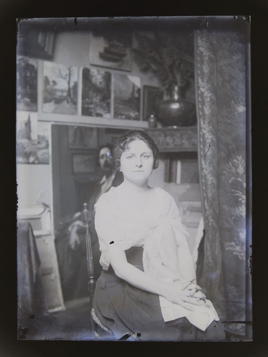 Portrait de jeune femme assise, les épaules entourées d'une étole brodée, posant dans l'atelier du peintre Léon Tirode, Studio Meusy, 4e quart 19e siècle, 1ère moitié 20e siècle