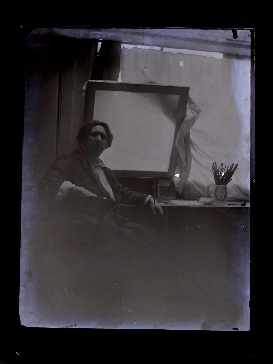 Portrait du peintre Léon Tirode dans son atelier assis devant une table de travail, assis sur la gauche, Studio Meusy, 4e quart 19e siècle, 1ère moitié 20e siècle