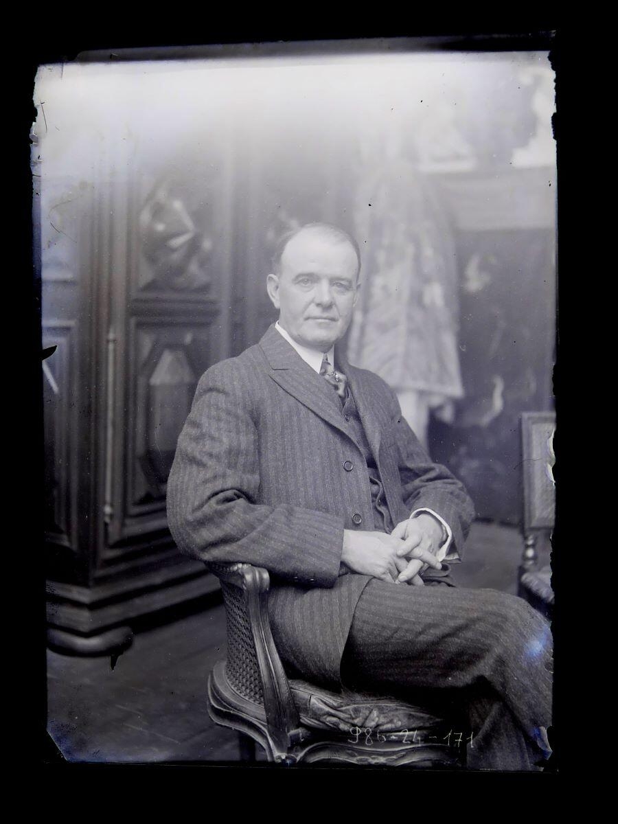 Portrait d'homme en costume rayé, jambes croisées, posant dans l'atelier_0