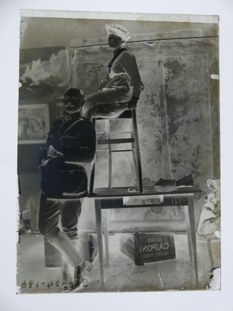 Portrait d'un homme en costume militaire et d'une femme assise posant dans l'atelier du peintre Léon Tirode_1