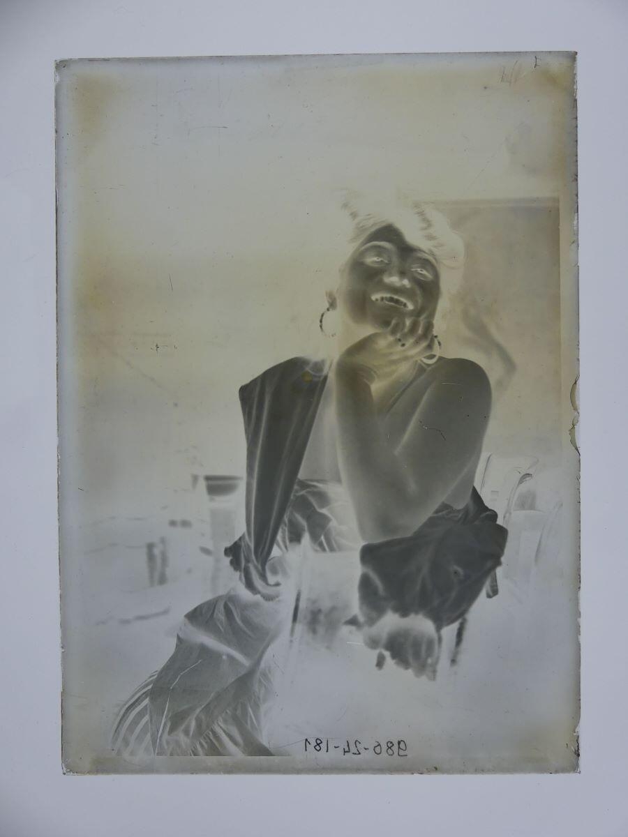 Modèle souriant, épaule nue, le menton dans la main droite, posant dans l'atelier_1