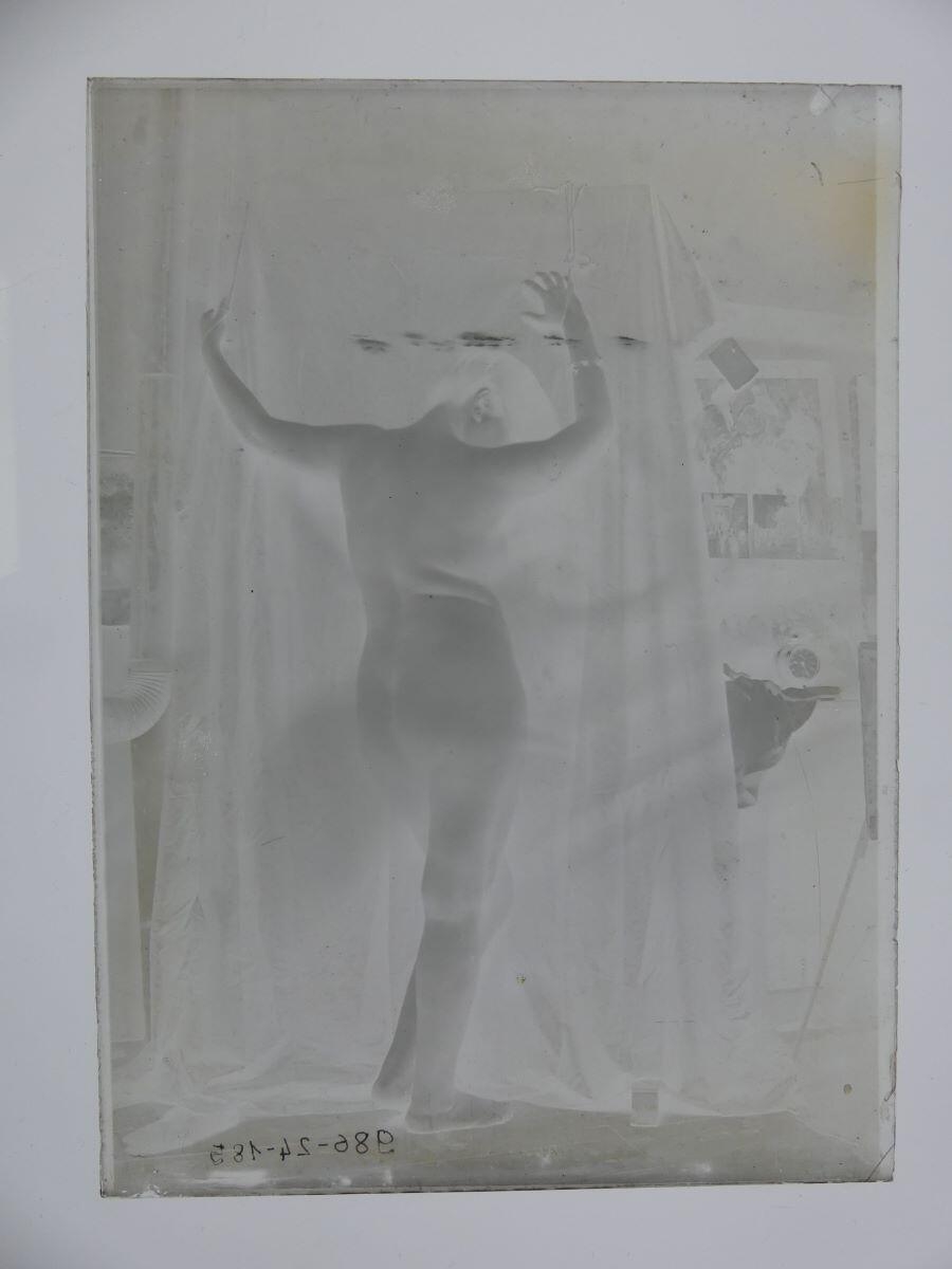 Femme nue, vue de dos, les bras levés, posant dans l'atelier_1