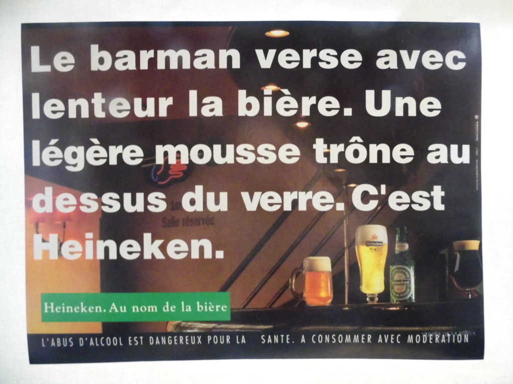 Le barman verse avec / lenteur la bière. Une / légère mousse trône au / dessus du verre. C'est / Heineken / Heineken. Au nom de la bière (titre inscrit), 1993-1994