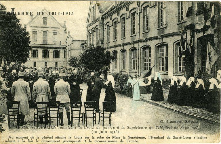 Guerre 1914-1915 - Le Général Jullien remettant la Croix de guerre à la Supérieure de l'Hôpital de Soissons (10 juin 1915). Au moment où le général attache la Croix sur la robe de Madame la Supérieure, l'étendard du Sacré-Coeur s'incline saluant à la fois le dévouement récompensé et la reconnaissance de l'armée_0