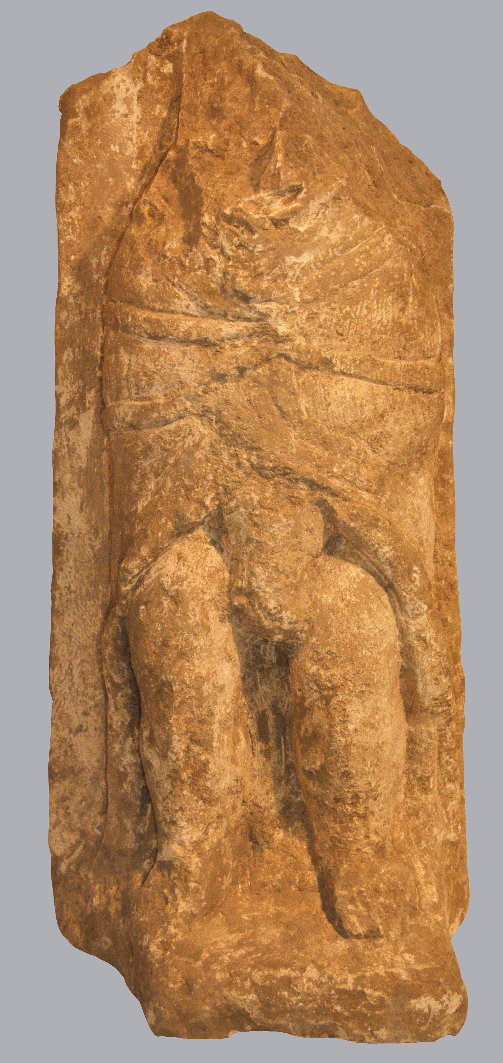 Ex-voto du temple de la forêt d’Halatte, priape habillé d’une longue cape ouverte sur le bas ventre et les jambes ; décapité_0