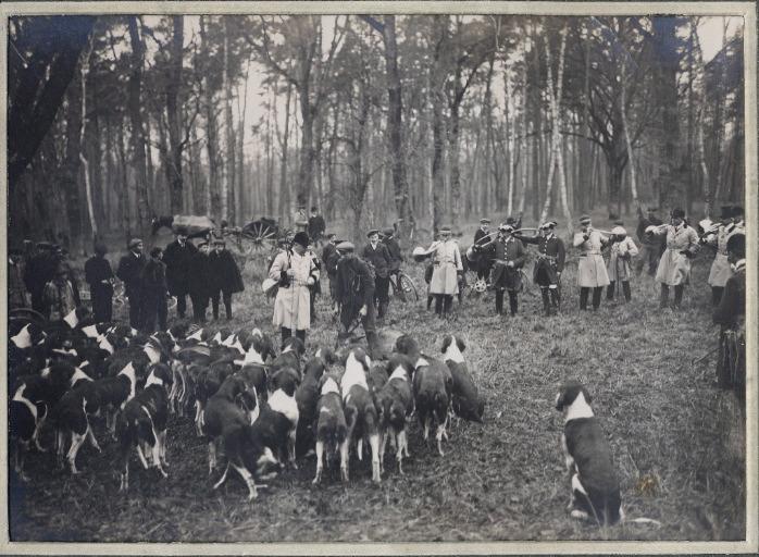Photographie d'un album en maroquin vert comprenant 24 photographies : Equipage Par Monts et Vallons, veneur présentant la nappe aux chiens lors de la curée, Georges Royer, 1920 avant