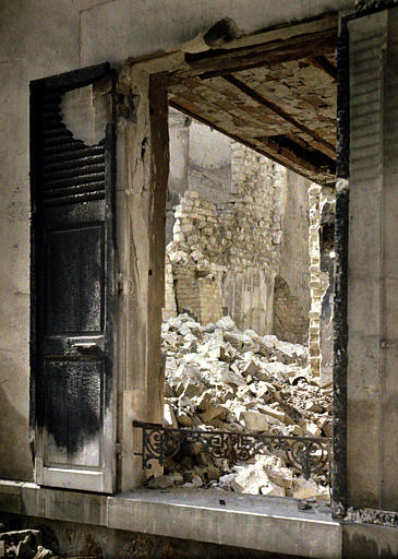 Vue prise de la rue par l'ouverture d'une fenêtre, sur les gravats amoncelés à l'intérieur