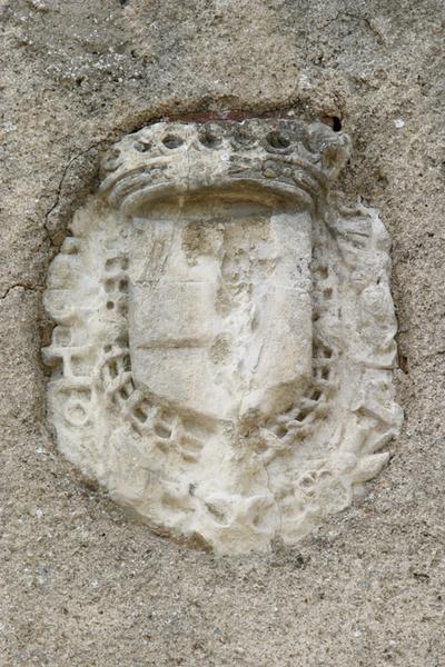 Pierre sculptée : écusson armorié couronné, encastré dans le mur latéral sud.