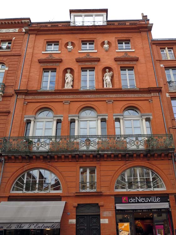 Face à la fontaine de la Trinité, façade est avec balcons en fer forgé, frise décorative en terre cuite et niches avec statues