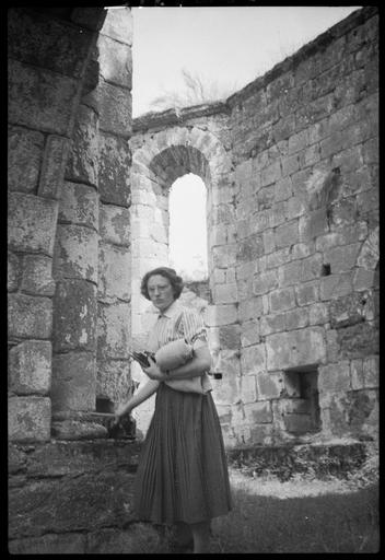 Intérieur : une femme devant mur en ruines