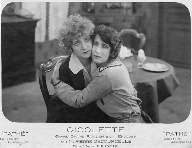 Séphora Mossé dans le rôle de Zelie Vauquelin et Elaine Vernon dans celui de Geneviève ou Marie, joue contre joue, sont assises sur la même chaise dans 'Gigolette' de Pierre Decourcelle et H. Pouctal (Pathé)