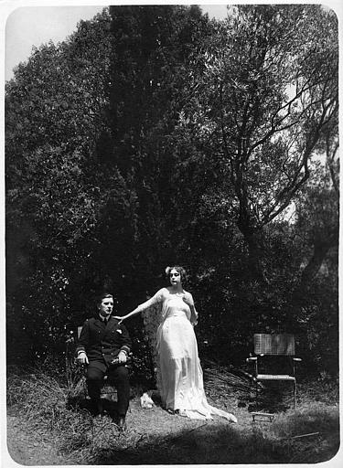 Nathalie Kovanko dans le rôle d'Hélène, debout, et un officier assis dans une chaise dans un jardin dans 'Jean d'Agrève' de René Leprince