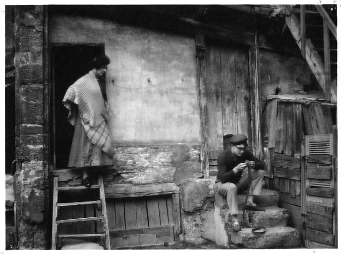 Nathalie Lissenko et Georges Charlia sur des marches à l'extérieur d'une habitation vétuste