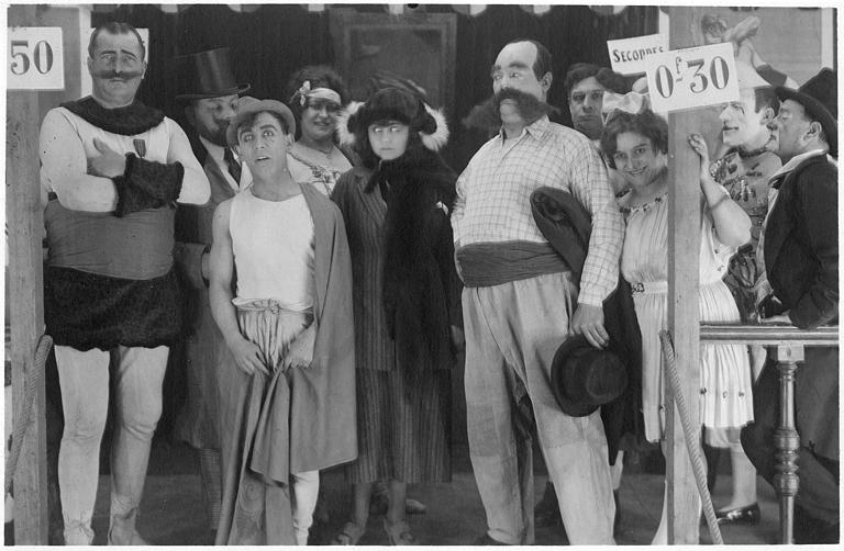 Rémond Frau qui interprète Dandy entouré de personnages de cirque sur une estrade : Florelle, Louis, Adolphe, Dalty, Pollos et Foch