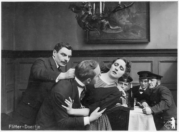 Dans un café, une femme tente de se défaire d'un homme qui l'étreint alors qu'un troisième cherche à les séparer : Martha Novelly et Rudolf Klein-Rogge