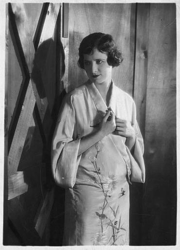 Lillian Hall-Davies, jouant la châtelaine, debout portant une robe de type asiatique dans 'La proie du vent' de René Clair