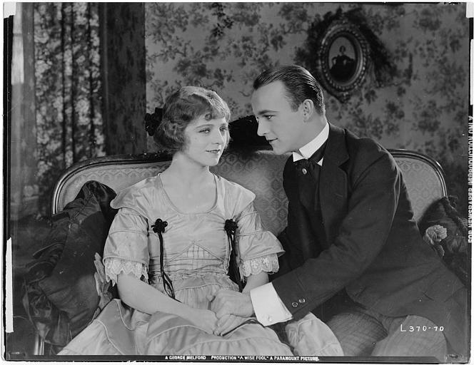 William Boyd dans le rôle de Gerard Fynes et Ann Forrest dans le rôle de Zoe Barbille souriant sur un canapé