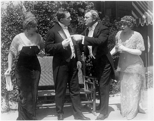 Deux hommes se disputant en compagnie de deux femmes en extérieur : Hobart Bosworth et Adele Farrington dans le rôle du couple Balderson dans 'The coutry mouse' d'Hobart Bosworth (Bosworth Inc)
