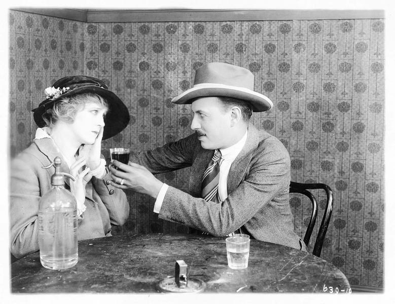 Un homme tendant un verre à Mollie Vaughn (B. Bennett)