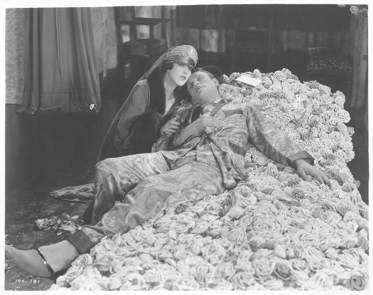 La reine (A. Pringle) aux côtés de Paul Verdayne (C. Nagel) qui est étendu sur le lit