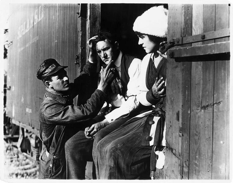 Helen (H. Gibson) à côté d'un homme blessé