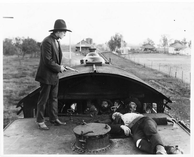 Un homme braquant son revolver sur un groupe de malfaiteurs