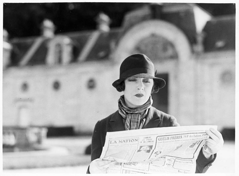 Une femme (G. Morlay) lisant le journal