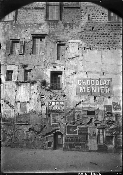 Façade sur la rue de la République, partie adossée au donjon ; affiches publicitaires