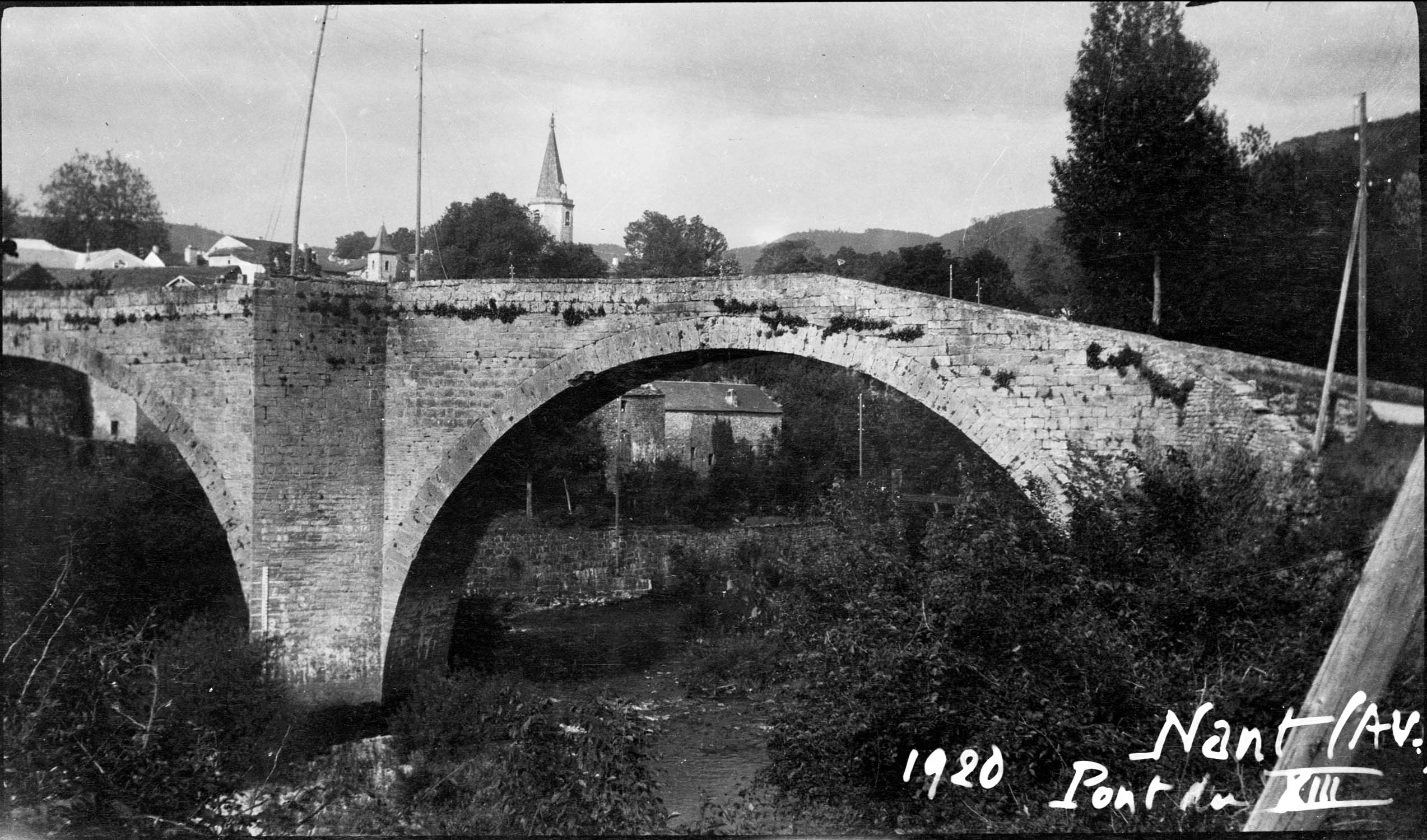 Une arche et un avant-bec, le clocher de l’église en arrière-plan