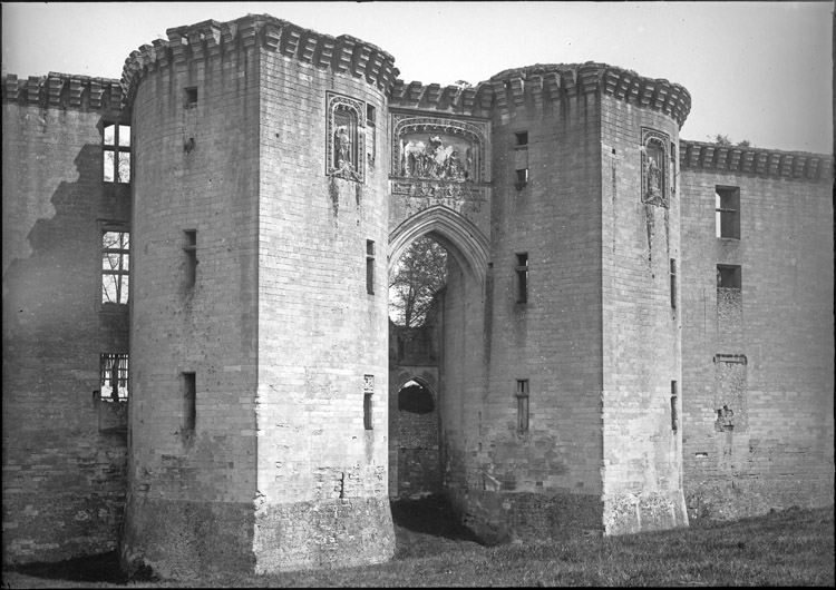 Façade ouest, châtelet d’entrée : tours couronnées de créneaux et porte monumentale surmontée d’un haut-relief